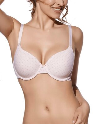 Sutiã rosa com aros e enchimento, estampa delicada de pequenos pontos, laço central e alças ajustáveis. Modelo posando com um sorriso e braço levemente erguido.