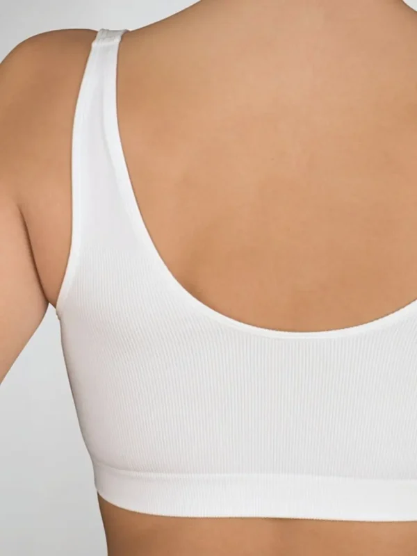 Costas de sutiã pós-cirúrgico branco, sem aros, sem costuras nas alças e em tecido suave e elástico, ideal para próteses e pele sensível.